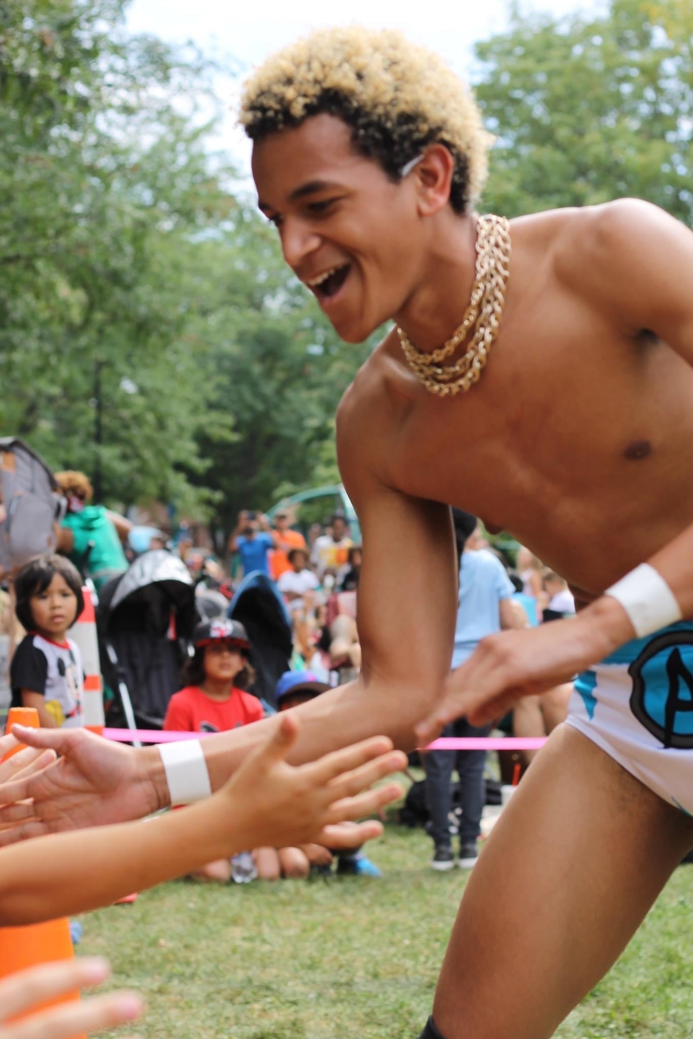 Adonis Allen at Lucha in the Park 2023 high fiving kids